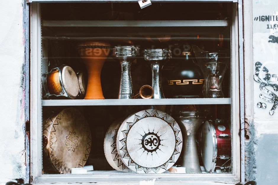 Display of diverse percussion instruments in a music shop window.